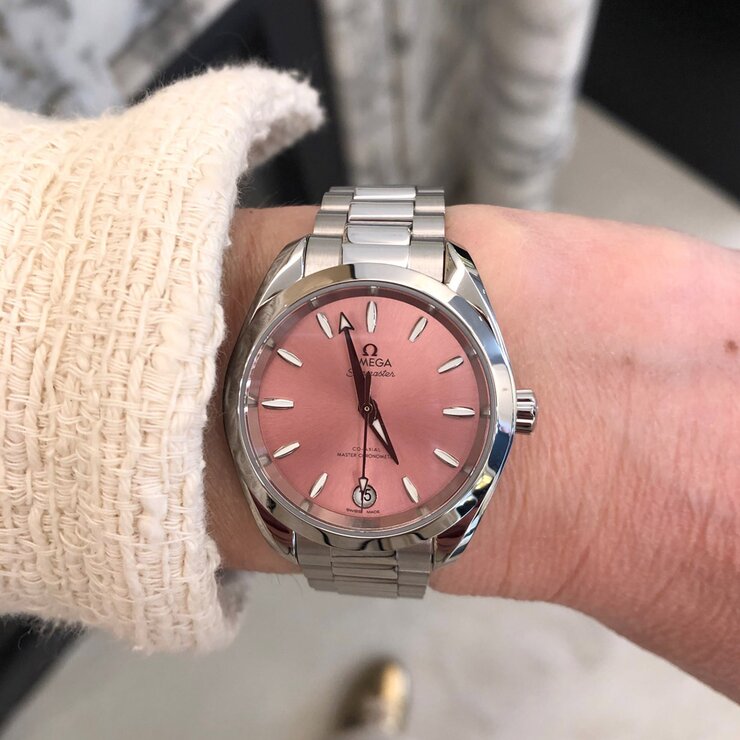 Omega horloge met een kast in staal, met een wijzerplaat in het roze en een diameter van 34 mm