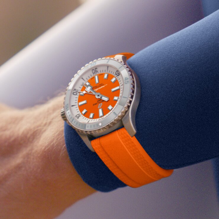 Breitling horloge met een kast in staal, met een wijzerplaat in het oranje en een diameter van 36 mm