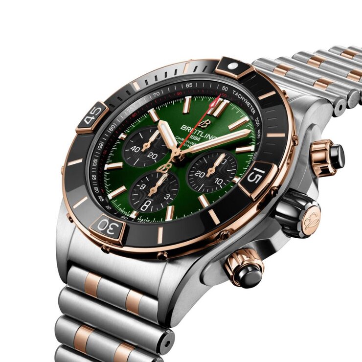 Breitling horloge met een kast in rosé goud op staal, met een wijzerplaat in het groen en een diameter van 44