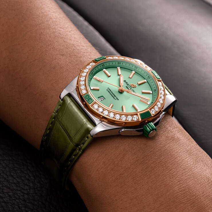 Breitling horloge met een kast in rosé goud op staal, met een wijzerplaat in het groen en een diameter van 38