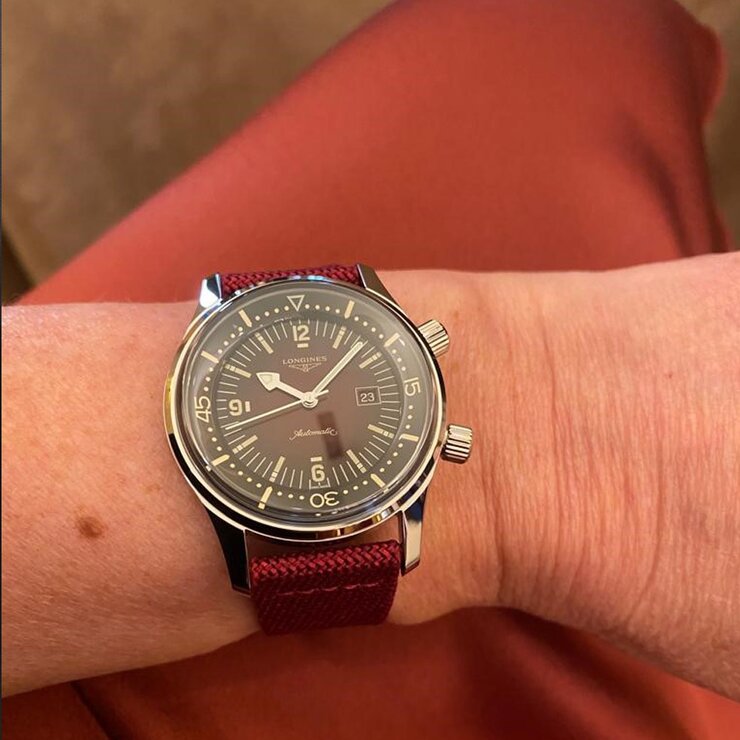 Longines horloge met een kast in staal, met een wijzerplaat in het rood en een diameter van 36 mm