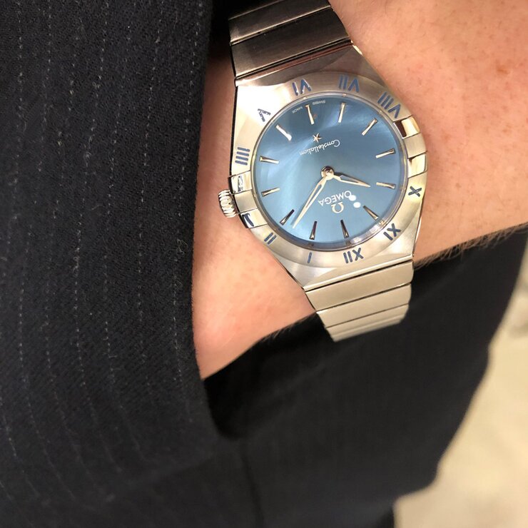 Omega horloge met een kast in staal, met een wijzerplaat in het blauw en een diameter van 28 mm