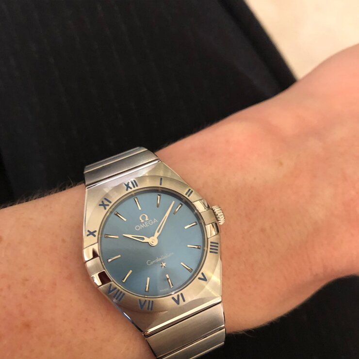 Omega horloge met een kast in staal, met een wijzerplaat in het blauw en een diameter van 28 mm