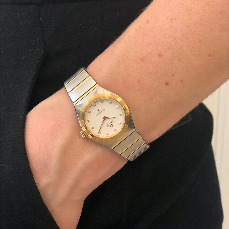 Omega horloge met een kast in geel goud op staal, met een wijzerplaat in het wit met  briljant en een diameter van 28 mm