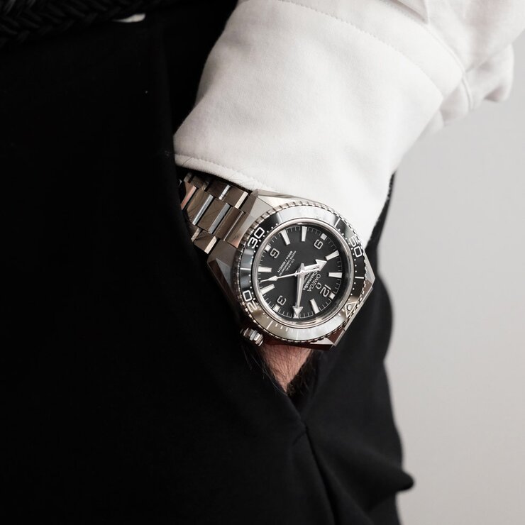 Omega horloge met een kast in keramiek op staal, met een wijzerplaat in het zwart en een diameter van 42 mm