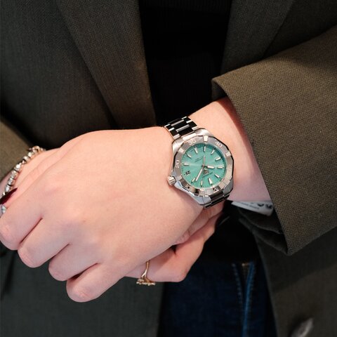 montre TAG Heuer avec un boîtier en acier, un cadran bleu et un diamètre de 34 mm